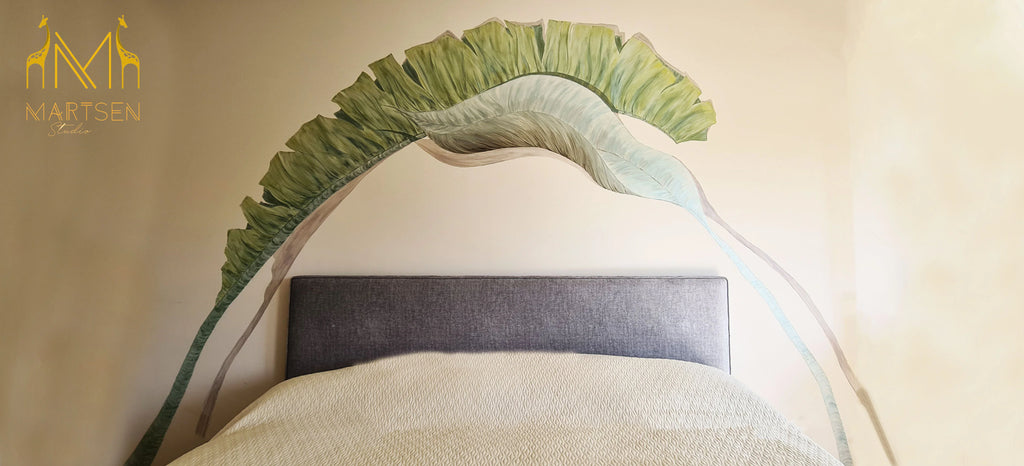 Diseño de cabecero de cama pintado sobre pared con hojas grandes verdes