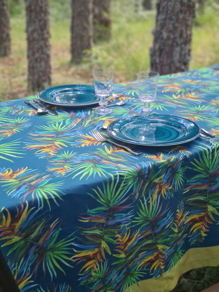Mesa exterior para dos con mantel azul marino de lino y algodón con hojas verdes