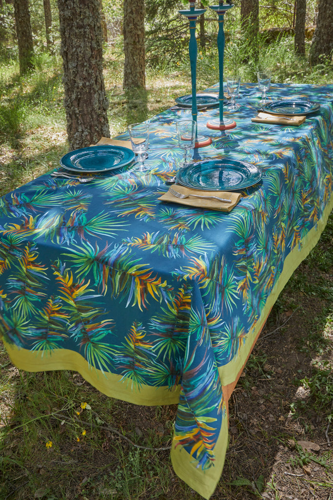 Mesa en el jardín preparada para cuatro con lino y algodón color azul con marco verde lima