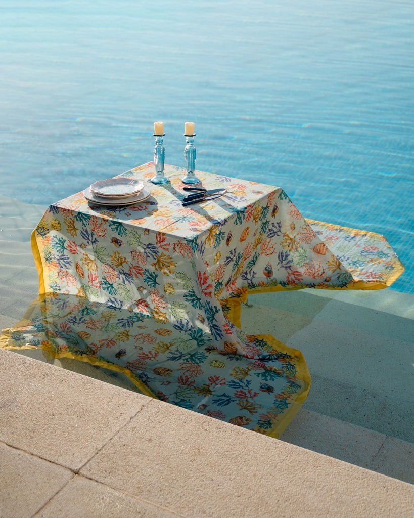Mesa sobre el agua con mantel de algodón y lino con corales y peces