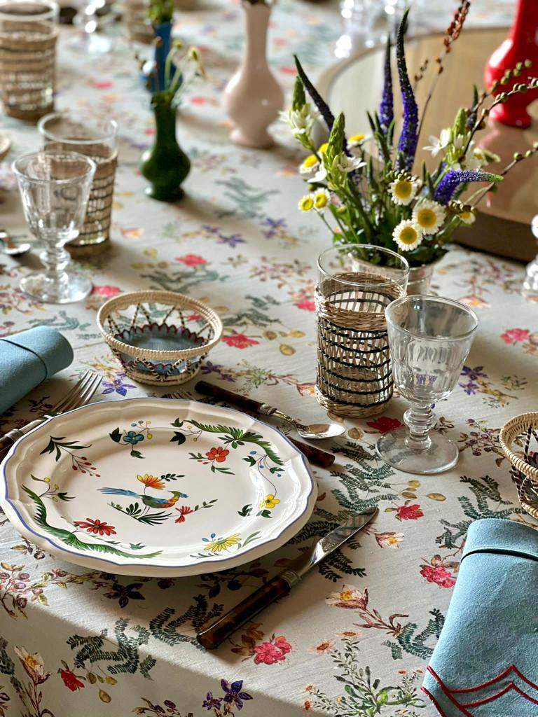 Detalle de mesa puesta y decorada con mantel de lino y algodón gris con flores