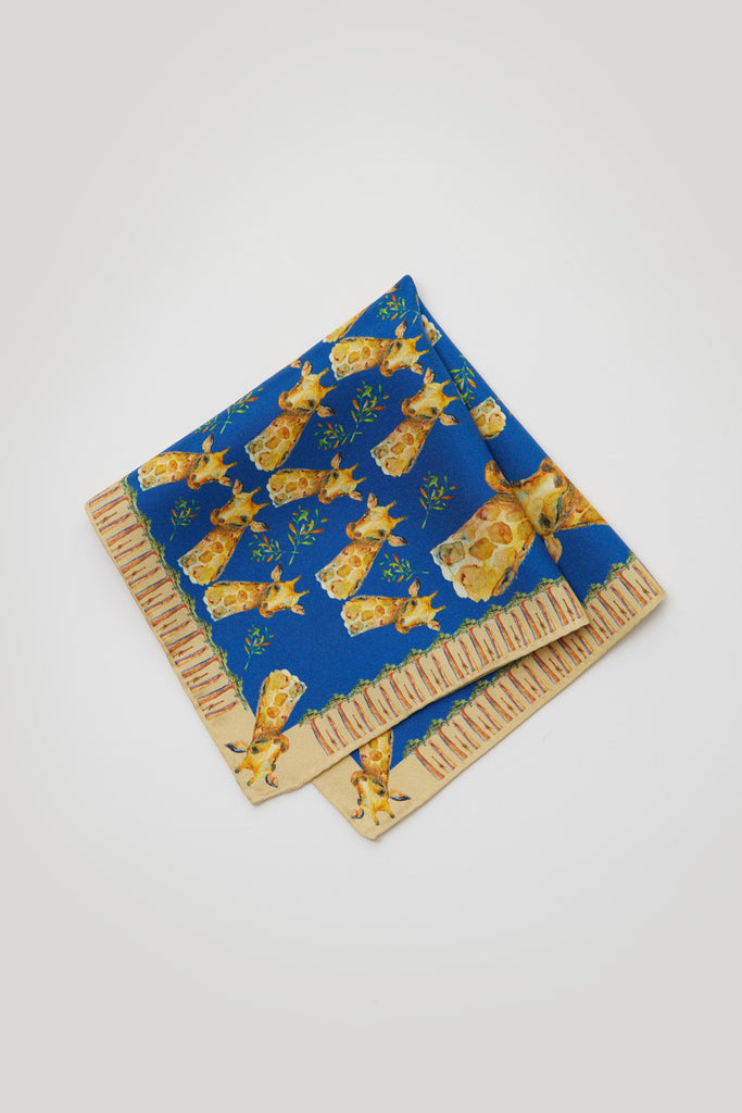Detalle pañuelo de bolsillo de seda natural azul con jirafas y baobabs