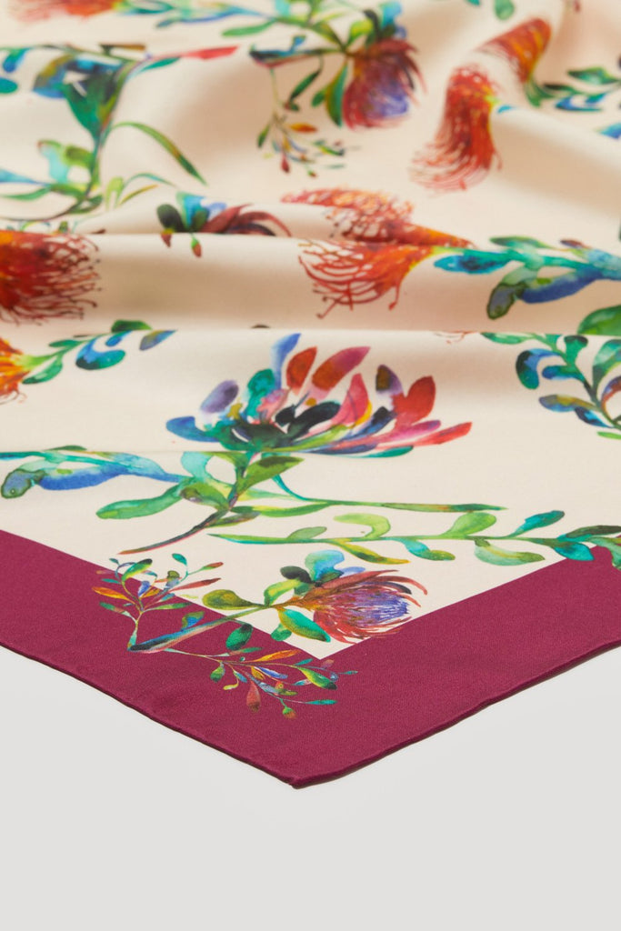 Detalle pañuelo de seda natural pura con forndo crudo y marco burdeos, con flores proteas