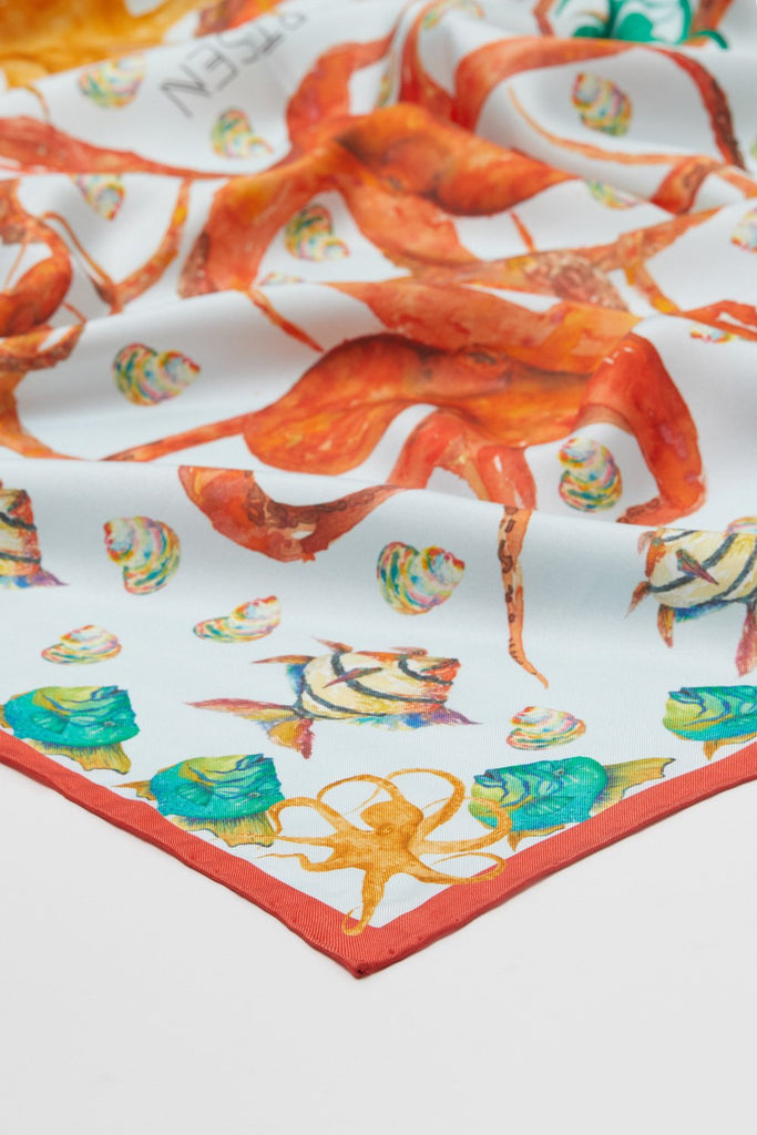 Detalle foulard de seda natural mujer con fondo blanco y animales marinos naranjas y verdes