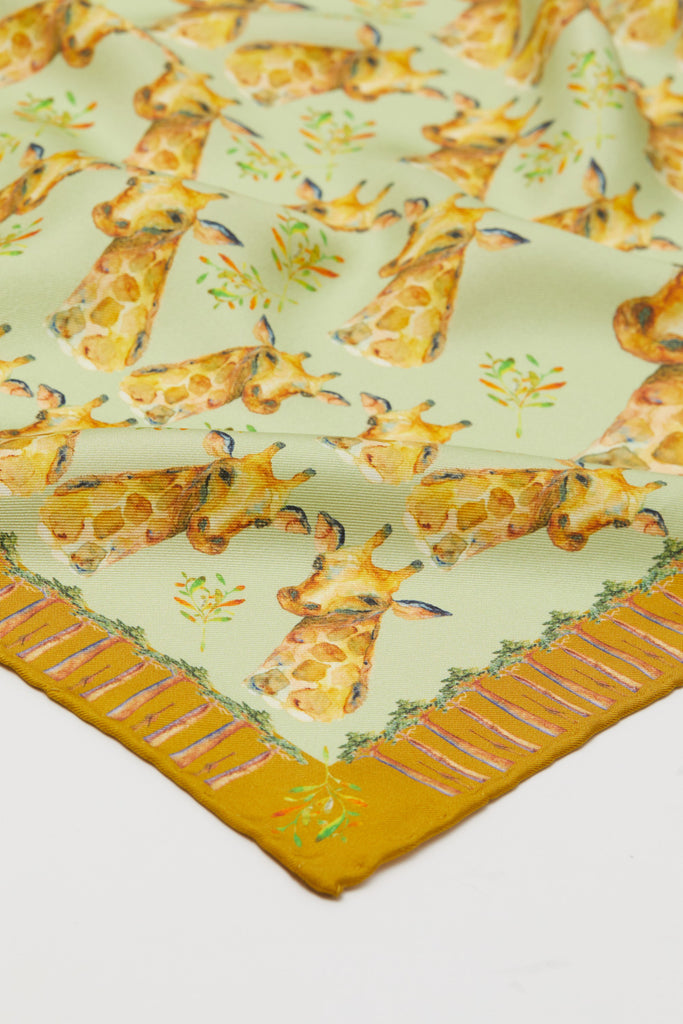 Detalle pañuelo de seda natural mediano amarillo con jirafas y  bao babs 