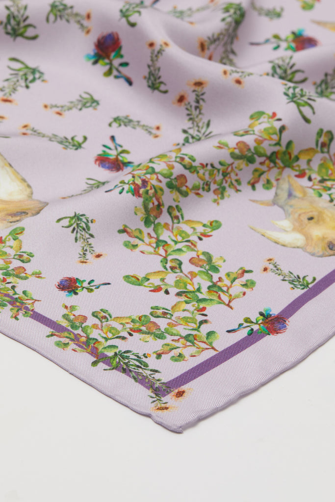 Detalle pañuelo de seda natural mediano lila con flores y rinocerontes