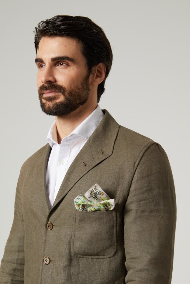 Hombre atractivo con pañuelo cuadrado de seda natural en bolsillo de chaqueta verde caza