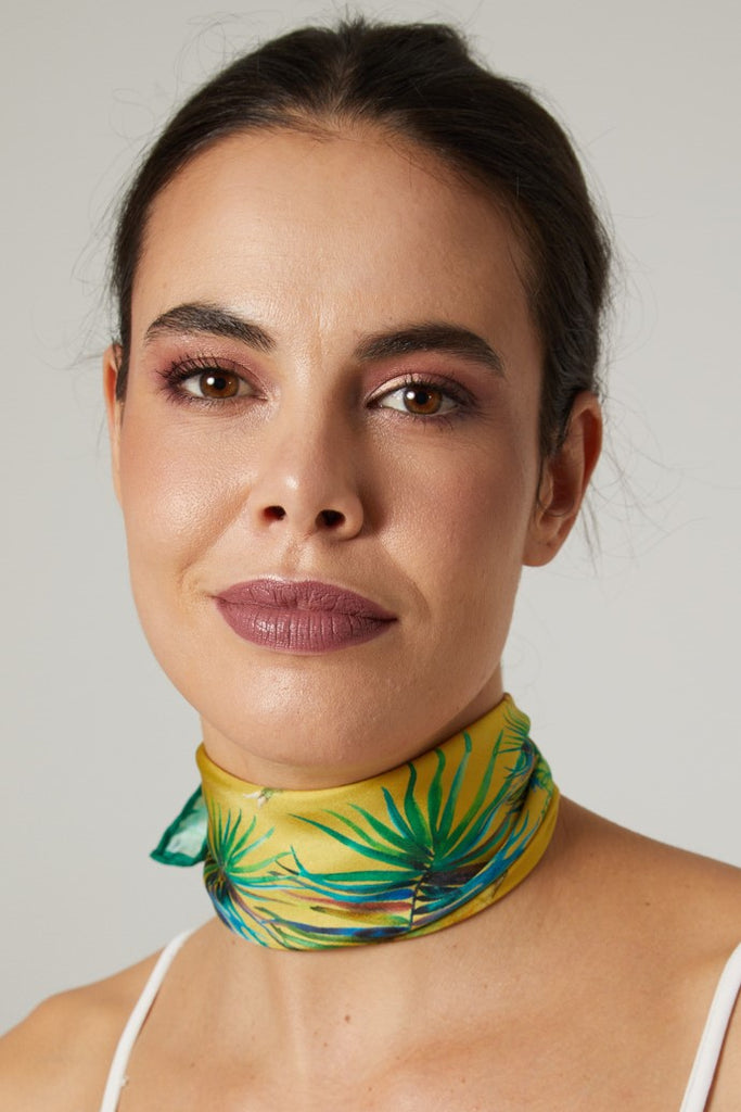 Rostro femenino con pañuelo de seda natural amarillo mediano con  hojas verdes 
