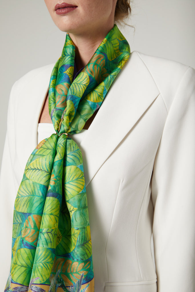 Detalle foulard de seda natural verde y azul con hojas y colibries al cuello 