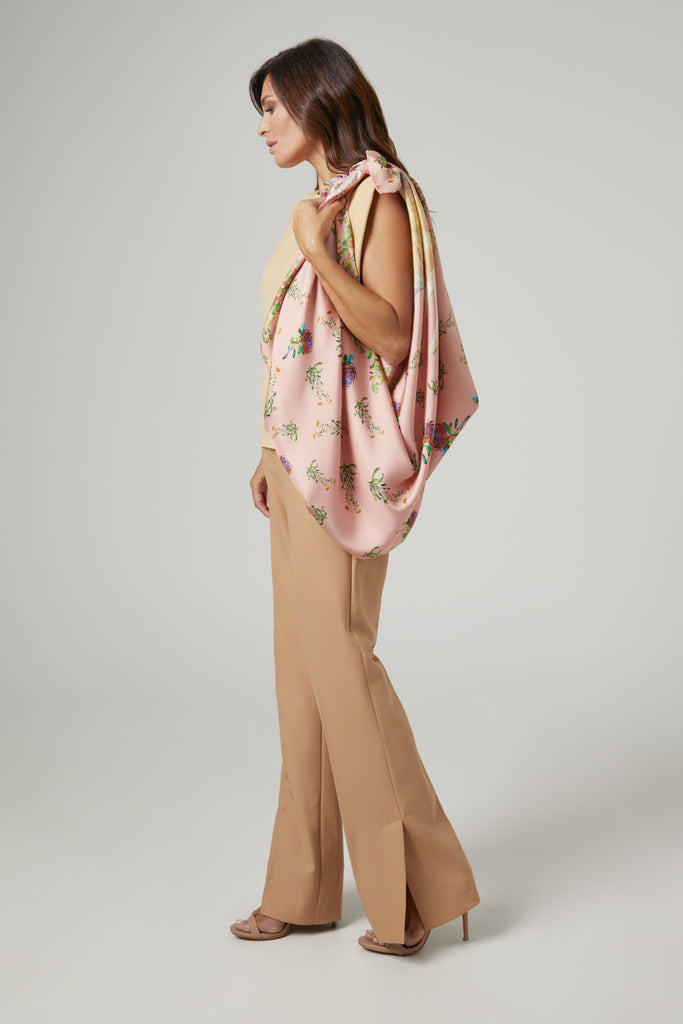 Mujer de pie con pañuelo de seda natural grande rosa colgado al hombro
