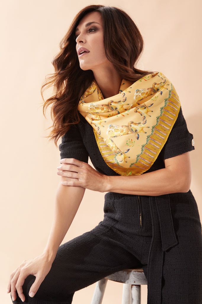 Mujer sentada con foulard de seda natural amarillo colocado al cuello 