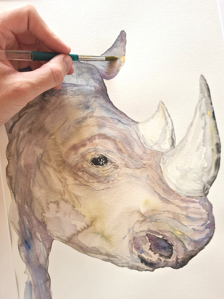 Detalle pincel pintando rinoceronte con acuarela